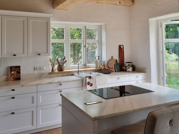 Moderne Küche in einem englischen Cottage mit Deckenbalken und Gartentür