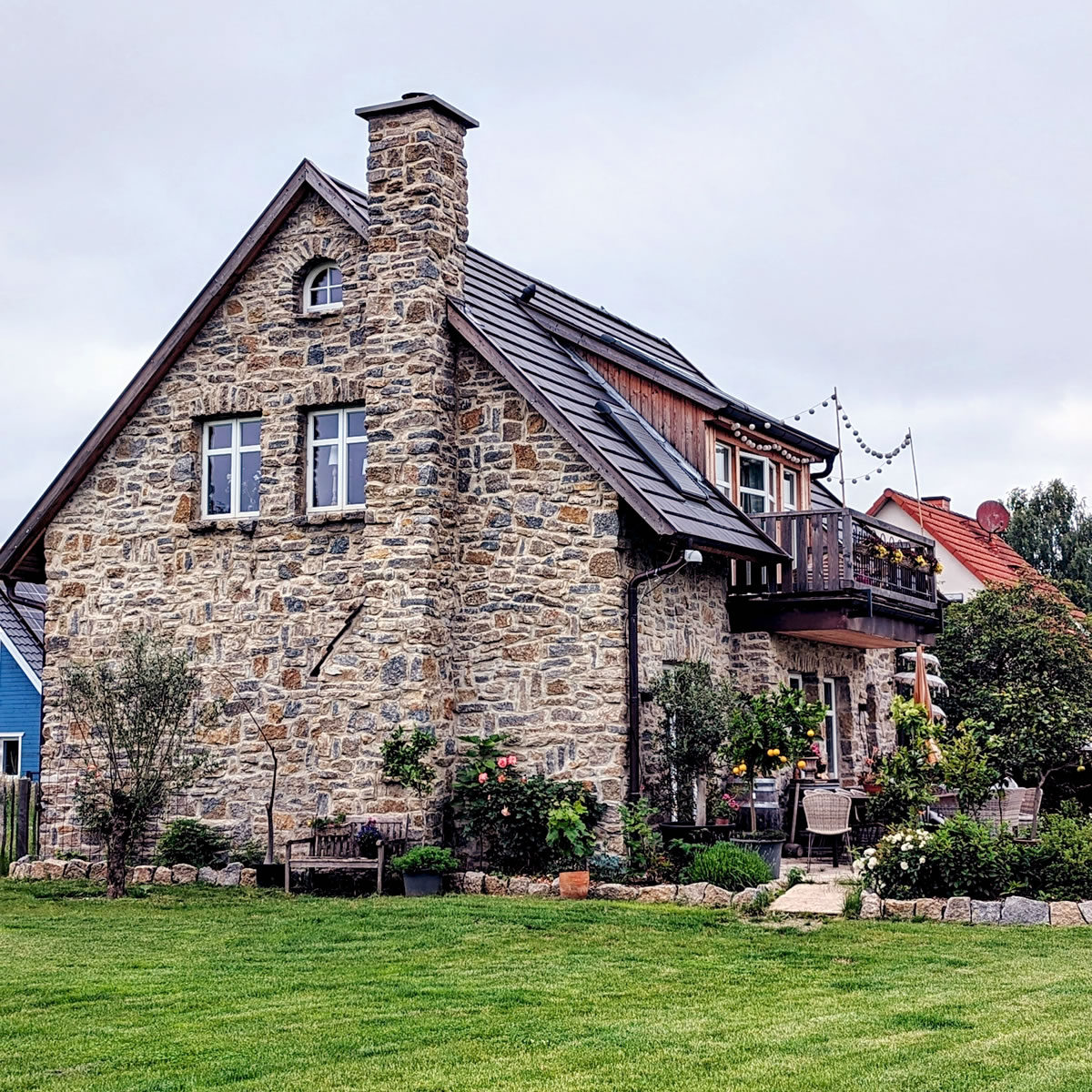 Muschelkalkfassade, Sprossenfenster und ein markanter Schornstein zieren die Goiebelseite - Englische Cottages aus Celle - Bauunternehmen Alan Berry