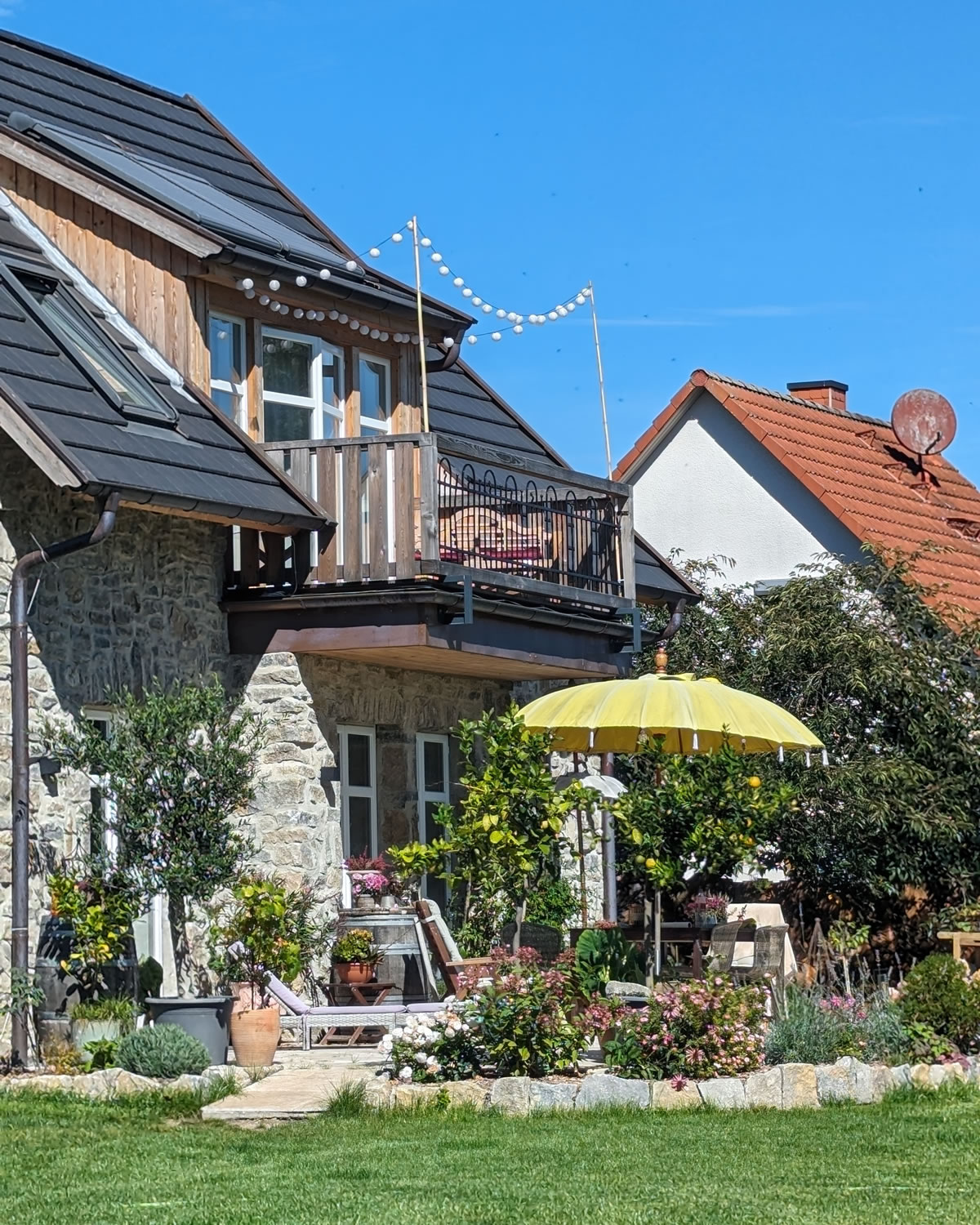 Passend zur Fassade ist die Terrasse mit Natursteinen eingefasst - Englische Cottages aus Celle - Bauunternehmen Alan Berry