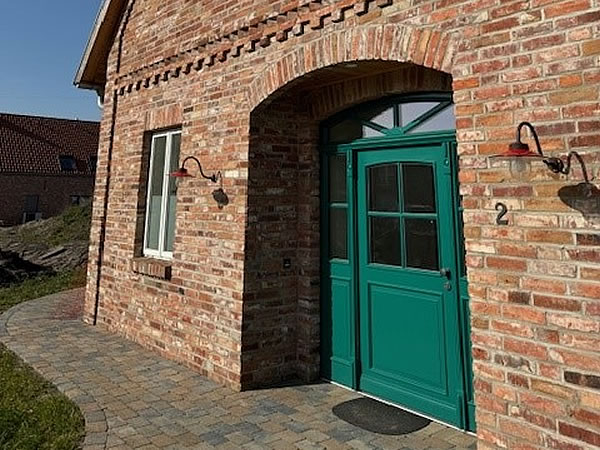 Grüne Haustür im Cottestil, passend zur Backsteinfassade - Englische Cottages aus Celle - Bauunternehmen Alan Berry